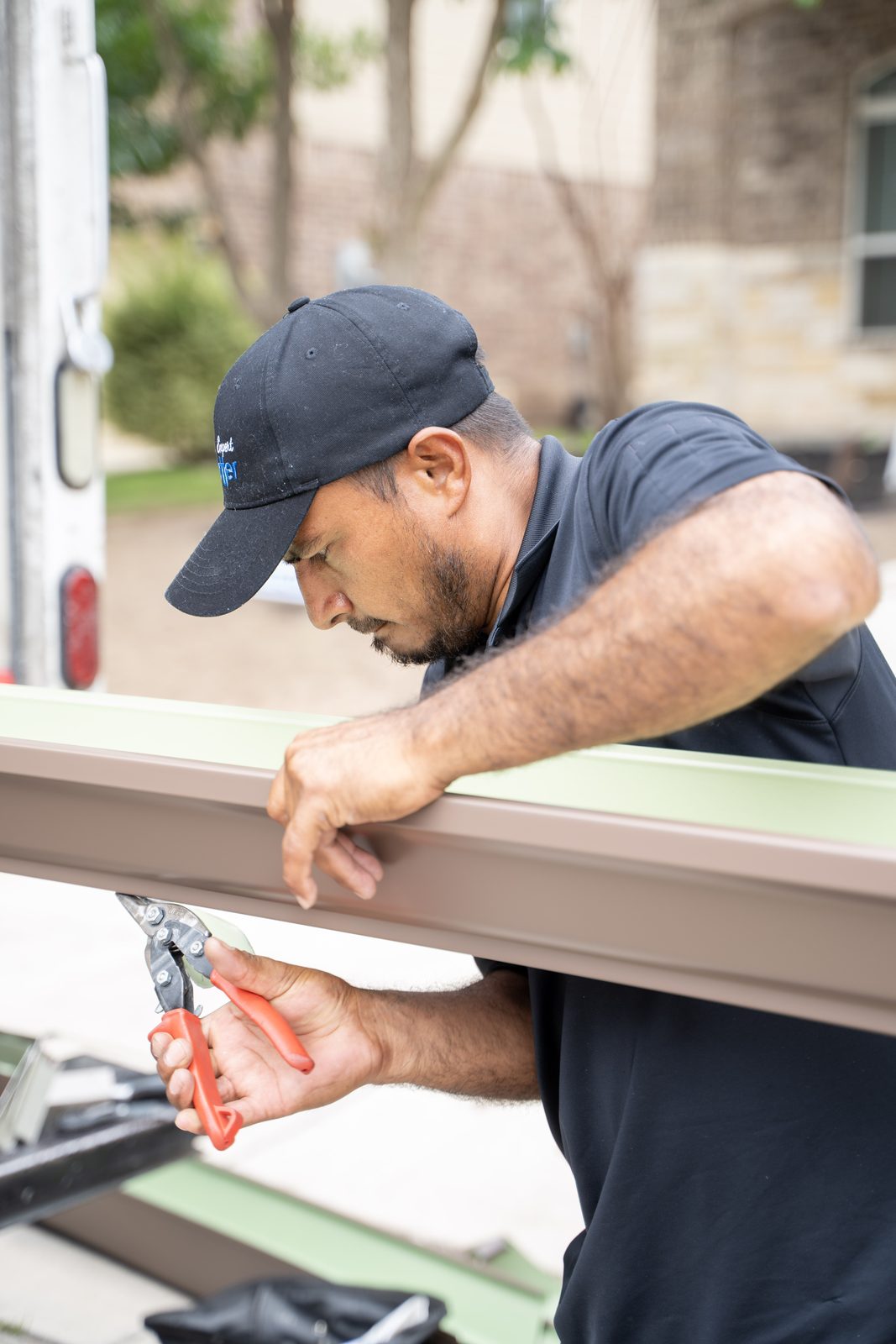 TX Gutter Expert technician cutting a seamless gutter section in San Antonio - TX