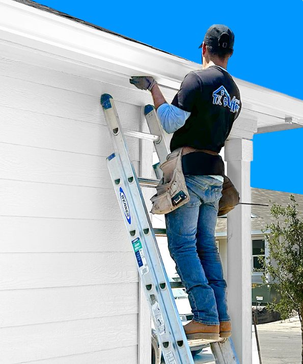 Gutter installation in San Antonio - TX by TX Gutter Expert technician on ladder